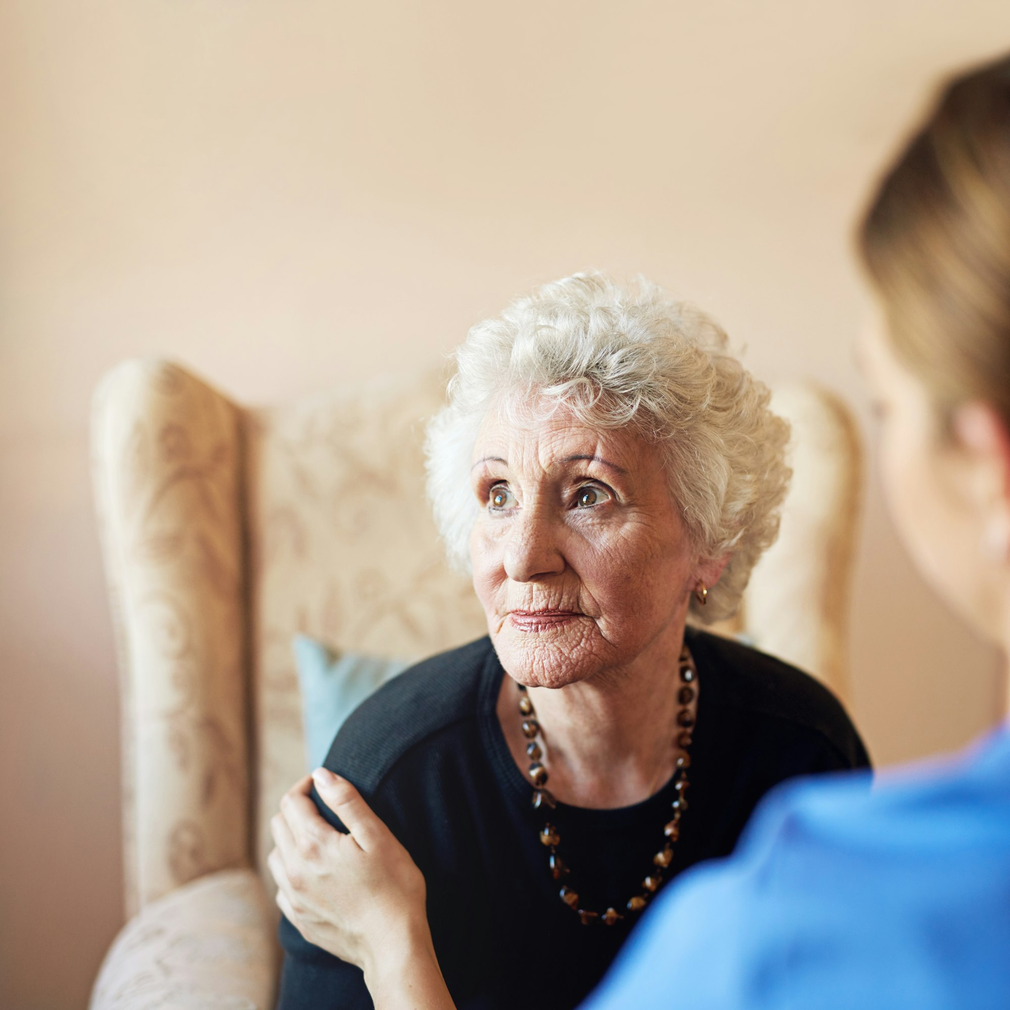 Thoughts of days gone by. Shot of a nurse caring for an elderly woman at a nursing home.